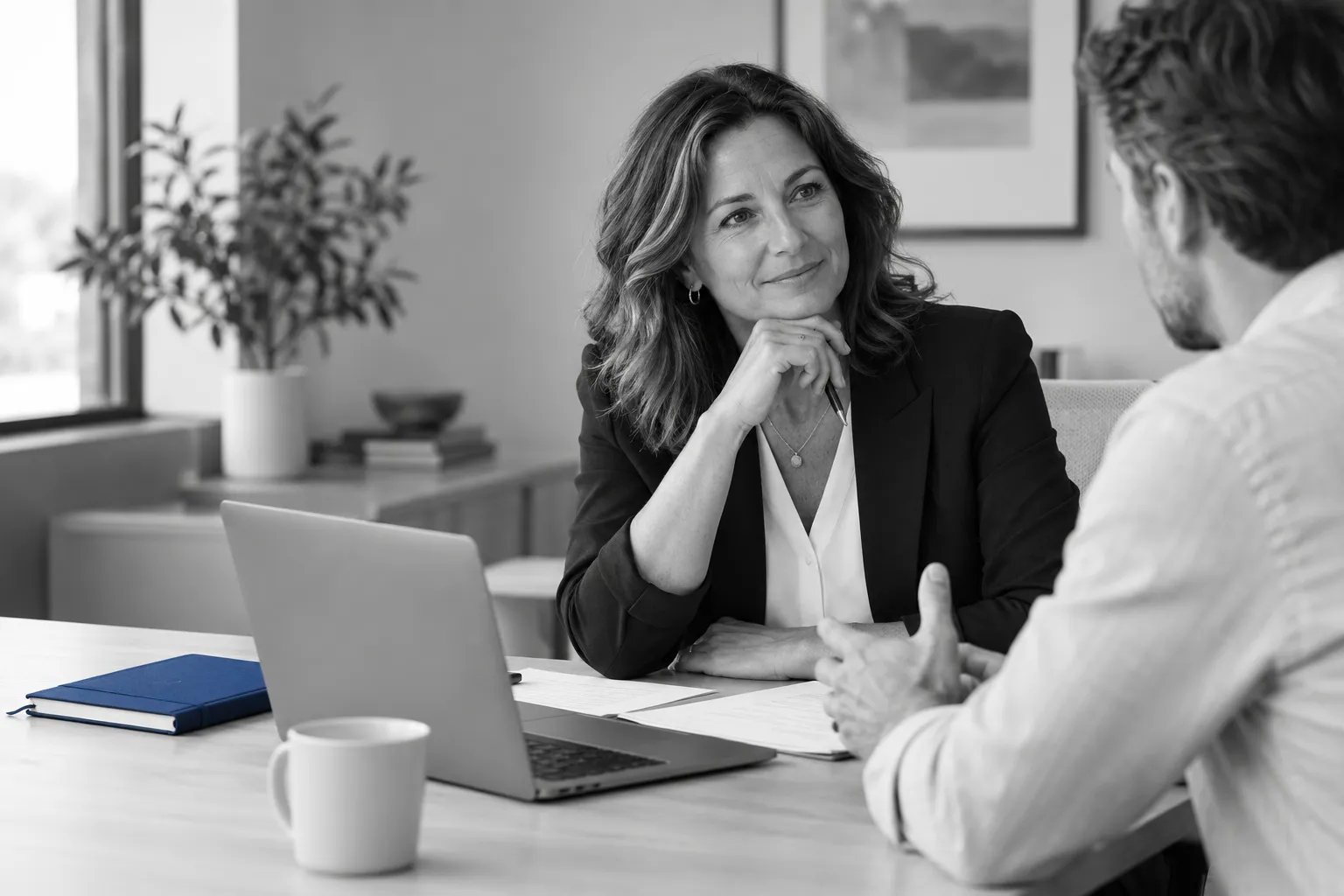 A professional service business owner and colleague discussing business priorities at an office desk